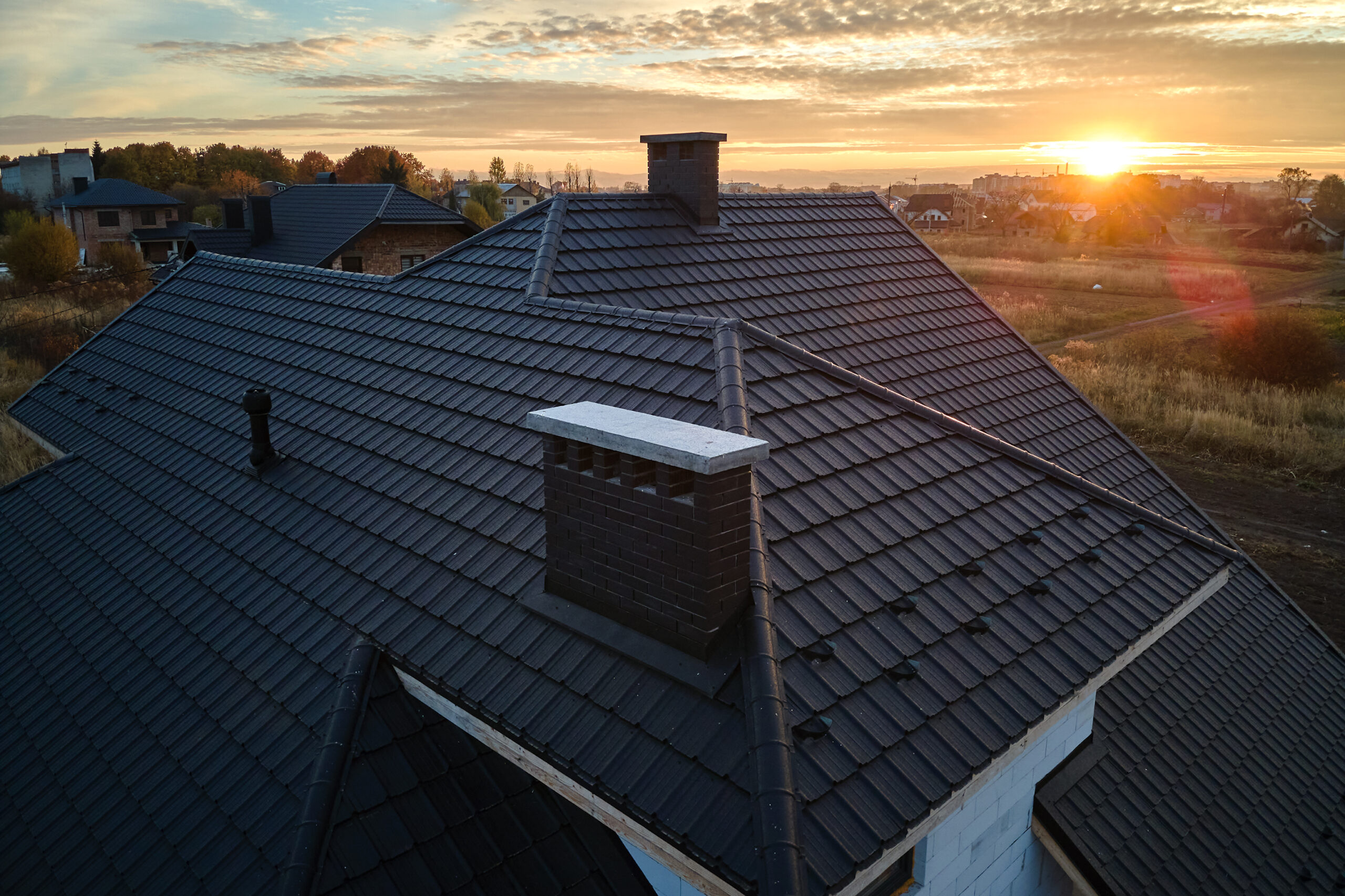 Picture of a roof with a sunset in the background