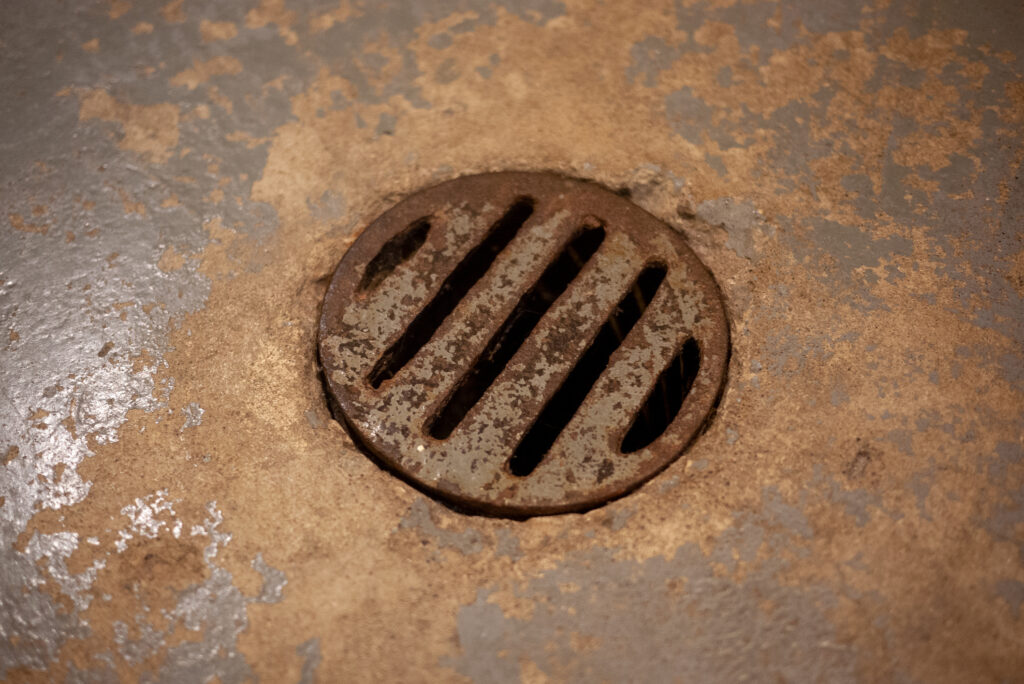 Close up of rusted basement floor drain